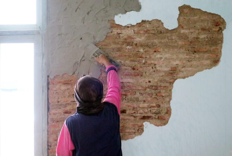 Fissures visibles sur le mur d’un ancien salon, près d’une fenêtre.